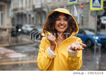 Catching the rain drops. Happy young woman in the city Catching the rain drops. Happy young woman in the city 139232218