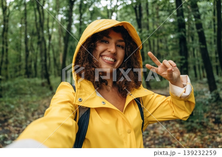 Selfie time. Young woman enjoying nature in the forest under the rain Selfie time. Young woman enjoying nature in the forest under the rain 139232259