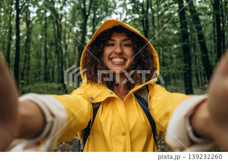 Selfie time. Young woman enjoying nature in the forest under the rain 139232260