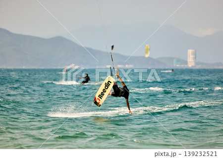 Kitesurfer High Jump Above Sea With City Background Kitesurfer High Jump Above Sea With City Background 139232521