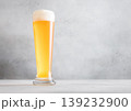 Glass pint of cold fresh lager beer with foam on light table background. 139232900