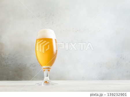 Glass pint of cold fresh lager beer with foam on light table background. 139232901