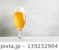 Glass of lager cold fresh preium beer with foam on light table background. 139232904