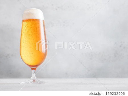 Elegant glass of lager preium beer with foam on light table background. 139232906