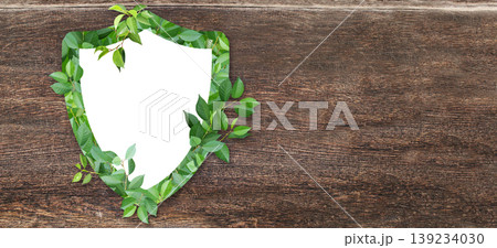 Horizontal wooden background with shield made from green leaves. Safety, global ecological resource, go green concept. Environmental conservation, wildlife protection, Eco-friendly, Green energy Horizontal wooden background with shield made from green leaves. Safety, global ecological resource, go green concept. Environmental conservation, wildlife protection, Eco-friendly, Green energy 139234030