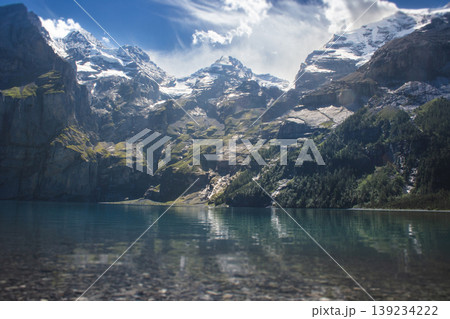 Panoramic view of Oeschinen Lake with a waterfall and the Bluemlisalp massif in Switzerland 139234222