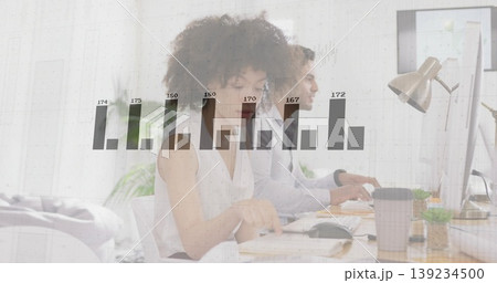 Typing colleagues in business attire analyzing data on monitors in office, with bar chart overlay Typing colleagues in business attire analyzing data on monitors in office, with bar chart overlay 139234500