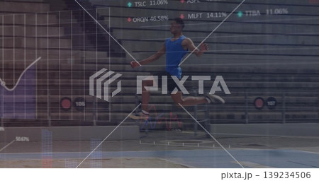 Launching male athlete performing long jump toward sand pit on track in stadium, with data overlay 139234506