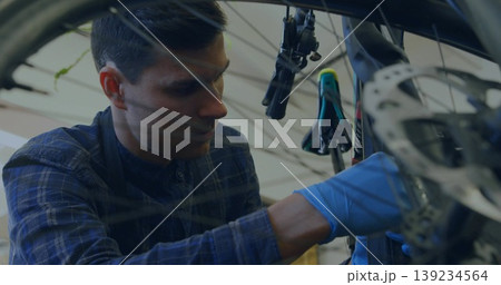 Mechanic wearing shirt and gloves fixing bicycle front-wheel disc brake rotor workshop, copy space Mechanic wearing shirt and gloves fixing bicycle front-wheel disc brake rotor workshop, copy space 139234564