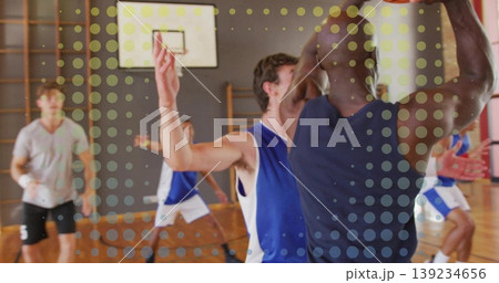 Player in navy sleeveless top shooting jump shot in gymnasium court, with basketball, hoop and net Player in navy sleeveless top shooting jump shot in gymnasium court, with basketball, hoop and net 139234656