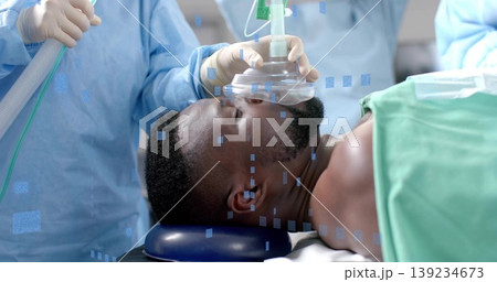 Holding anesthesia mask, staff in scrubs securing patient airway in operating room, with drape Holding anesthesia mask, staff in scrubs securing patient airway in operating room, with drape 139234673