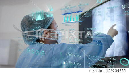 Pointing doctor in scrubs in exam room, using display showing X-ray arm, financial data, copy space Pointing doctor in scrubs in exam room, using display showing X-ray arm, financial data, copy space 139234853