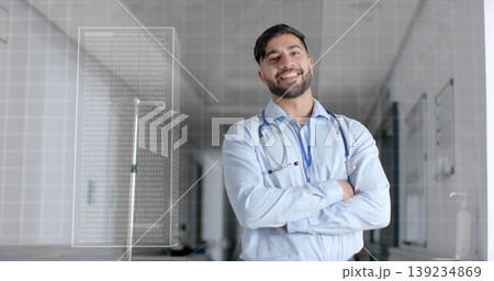 Smiling doctor standing in hospital corridor, with stethoscope, ID badge and binary code panel Smiling doctor standing in hospital corridor, with stethoscope, ID badge and binary code panel 139234869