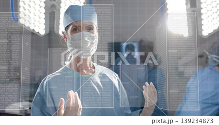 Manipulating surgeon wearing gloves interacting with hologram panels in OR under surgical lights Manipulating surgeon wearing gloves interacting with hologram panels in OR under surgical lights 139234873