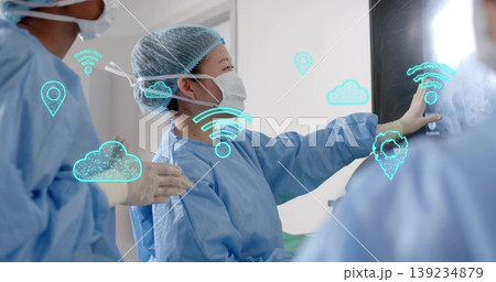 Touching Korean female surgeon examining monitor at OR wearing gown, mask and gloves, digital icons Touching Korean female surgeon examining monitor at OR wearing gown, mask and gloves, digital icons 139234879