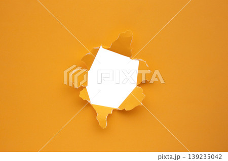 Torn ripped orange paper hole isolated on white background Torn ripped orange paper hole isolated on white background 139235042