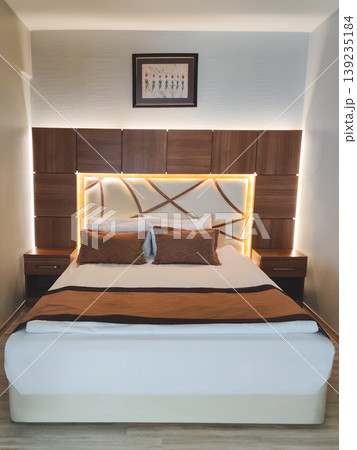 Modern hotel bed with integrated warm lighting and wooden headboard Modern hotel bed with integrated warm lighting and wooden headboard 139235184
