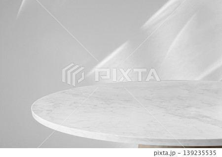 Round marble table top with abstract shadow drop on white wall background for mockup product display Round marble table top with abstract shadow drop on white wall background for mockup product display 139235535