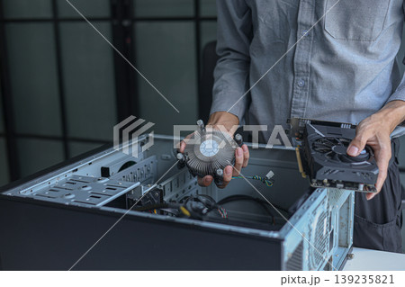Close-up of electronic technician hands working on computer repair. 139235821