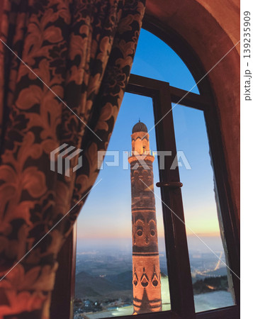 View of Mardin Ulu Mosque minaret through a window at sunset 139235909