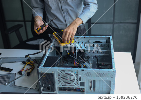 IT engineer installing components inside a computer system unit for upgrading computer PC. IT engineer installing components inside a computer system unit for upgrading computer PC. 139236270