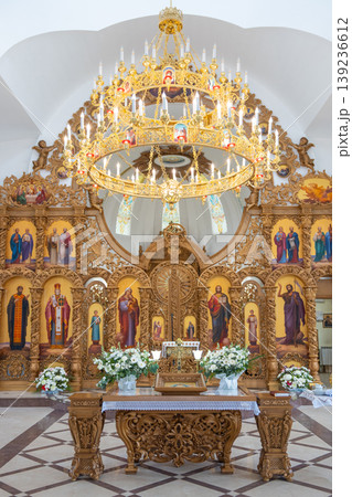 Grand church interior with golden chandelier and carved iconostasis 139236612