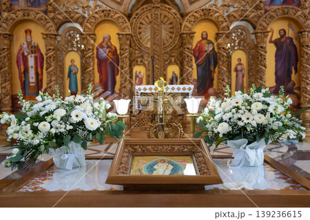 Ornate iconostasis and altar with white floral arrangements Ornate iconostasis and altar with white floral arrangements 139236615