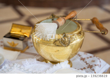 Golden baptismal bowl with an angel ornament and aspergillum Golden baptismal bowl with an angel ornament and aspergillum 139236619