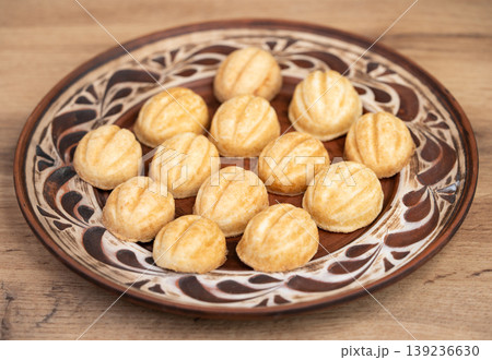 Traditional walnut-shaped cookies on a patterned ceramic plate Traditional walnut-shaped cookies on a patterned ceramic plate 139236630