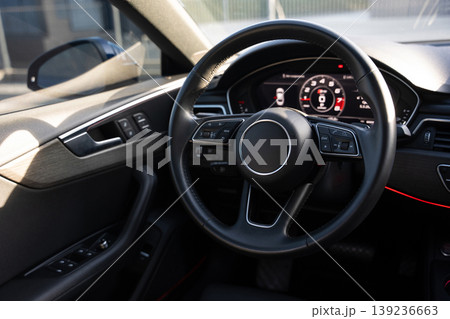 Interior view of a modern luxury car featuring the steering wheel and digital dashboard Interior view of a modern luxury car featuring the steering wheel and digital dashboard 139236663