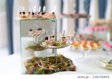 Gourmet appetizers on tiered serving stands at a catered event 139236809