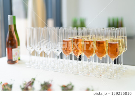 Row of champagne glasses filled with sparkling wine at a catered event 139236810