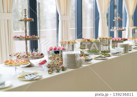 Long buffet table with assorted gourmet appetizers and desserts 139236811