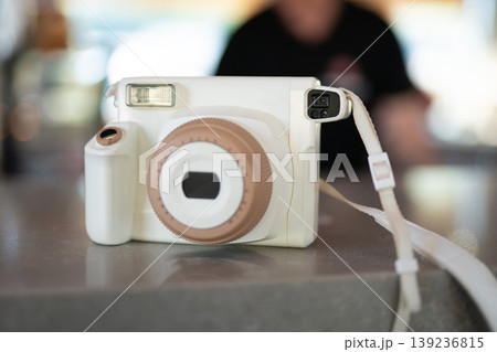 White instant camera sitting on a counter White instant camera sitting on a counter 139236815
