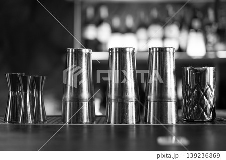 Professional bar tools and shaker tins in a monochrome row Professional bar tools and shaker tins in a monochrome row 139236869