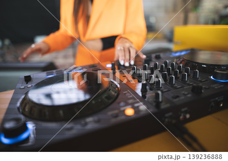 a DJ plays music on a controller at a party 139236888