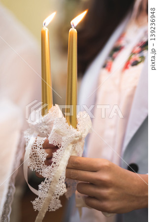 Beautifully burning candle held in hands in the church 139236948