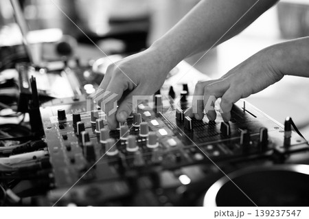 Black and white close-up of DJ hands mixing music on professional equipment Black and white close-up of DJ hands mixing music on professional equipment 139237547