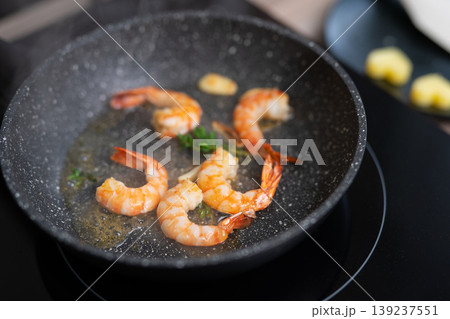 Sizzling shrimp with garlic and fresh herbs in a frying pan 139237551