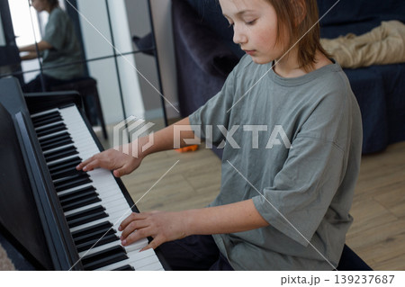 Handsome teen boy enjoy playing practicing electronic piano keyboard Handsome teen boy enjoy playing practicing electronic piano keyboard 139237687