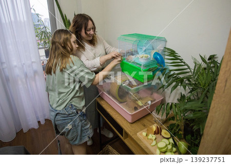 A woman and a girl work together to take care of a pet in a smal A woman and a girl work together to take care of a pet in a smal 139237751