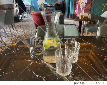 limonade jug with glasses on the table in restaurant 139237764