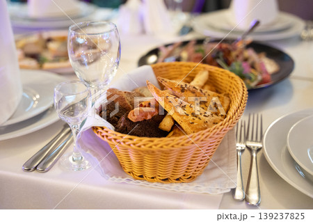 Elegant banquet table setting with bread basket and appetizers 139237825