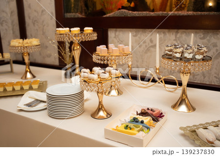Elegant dessert buffet with assorted gourmet sweets on gold stands 139237830