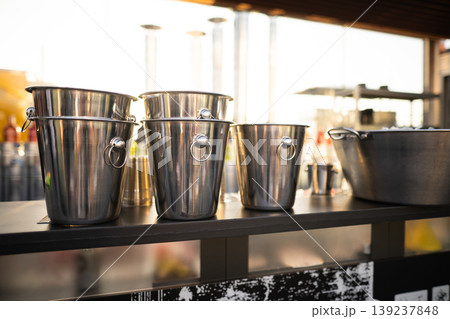metal ice bucket on bar counter in sunlight 139237848