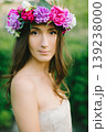 Close up portrait of a beautiful young girl with flower wreath in a sunny garden 139238000