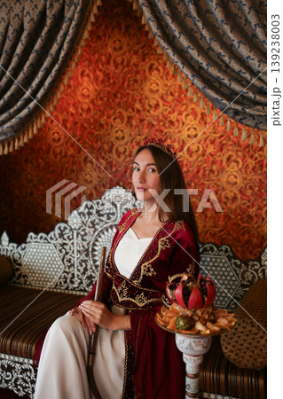 Young girl in traditional Turkish costume sitting with hookah in luxury oriental interior Young girl in traditional Turkish costume sitting with hookah in luxury oriental interior 139238003