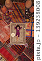 a beautiful girl in dress in a traditional turkish interior with many carpets on the wall 139238008