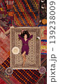 a beautiful girl in dress in a traditional turkish interior with many carpets on the wall 139238009