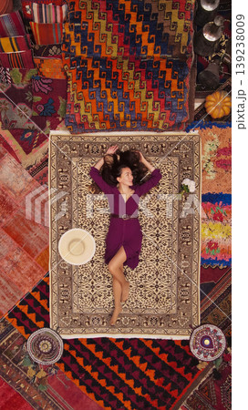 a beautiful girl in dress in a traditional turkish interior with many carpets on the wall 139238009